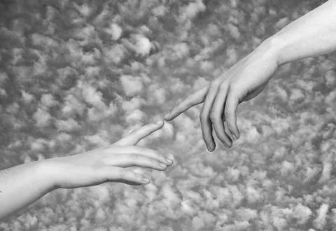 Two hands on a light background, a replica of the plot of Michelangelo's The  Fotos de archivo