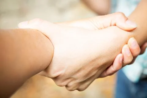 Two hands locked. Team work and agreement setting concept. Women solidarity and Stock Photos