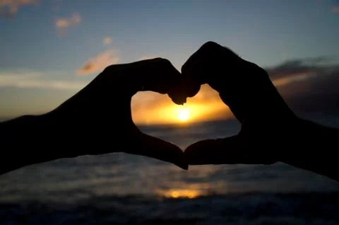 Two hands making a heart over the sunset. Foto stock