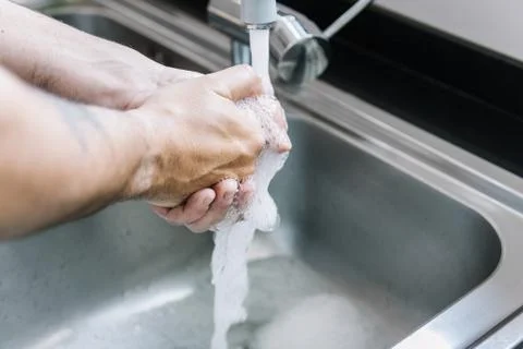 Two hands of a man taking off the soap with water Stock Photos
