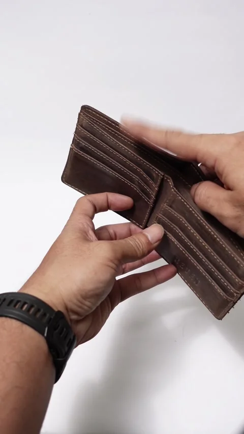 Two hands open an old brown wallet showing it completely empty Stock Footage 320564486