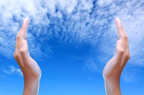 Two hands over the blue sky Stock Photos