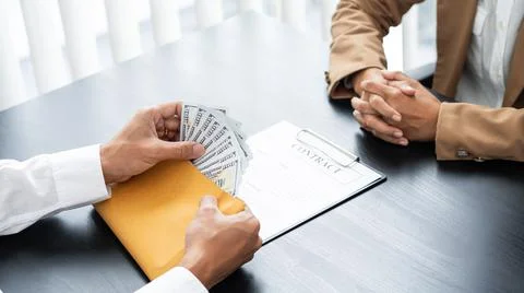 Two hands passing bills making agreement to initiate the new business Stock Photos