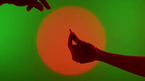 Two Hands Passing a Capsule Against Vibrant Background Stock Footage 313283053