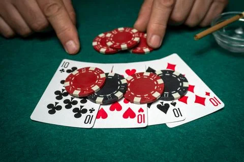 Two hands place poker chips on a green table where four of a kind or quads .. Stock Photos