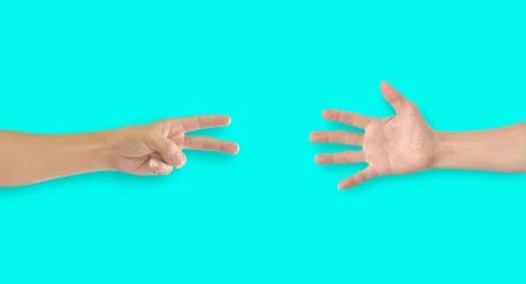Two hands playing rock-paper-scissors on blue background Stock Photos