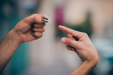 Two hands presenting Palestine flag pin Foto stock