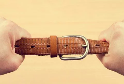Two hands pulling a leather belt Stock Photos