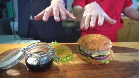 Two hands reaching out for a hamburger Stock Footage 73814822