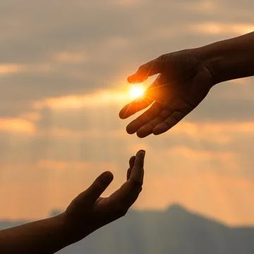 Two hands reaching toward each other with sun flare between fingers at gold.. Stock Photos