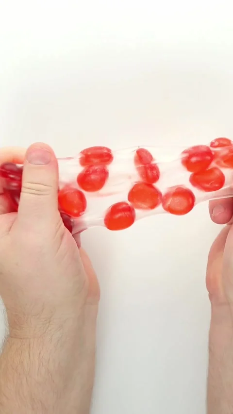 Two hands repeatedly compressing red bubble gel fidget ball Video stock 336264764