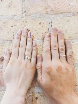 Two hands with rings on a  brick wall Stock Photos