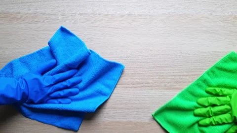 Two hands in rubber gloves wipe the table with microfiber cloths. Stock Footage 255037457