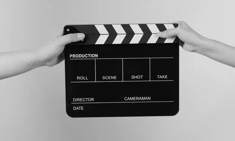 Two hands send and hold Black clapper board or movie slate . Black and whit.. Stock Photos