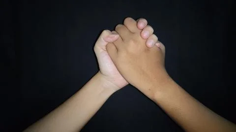 Two hands shaking which means friendship.Isolated on black background 写真素材