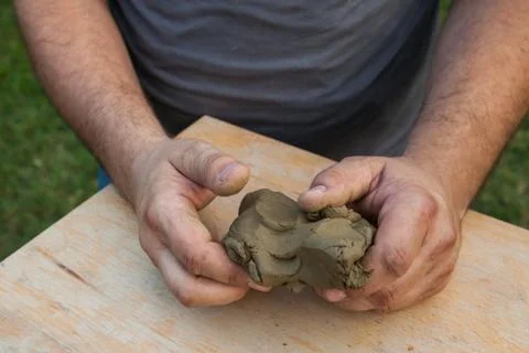 Two hands shaped piece of clay Stock Photos