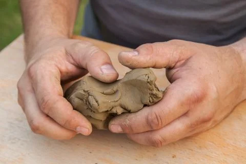 Two hands shaped piece of clay Stock Photos