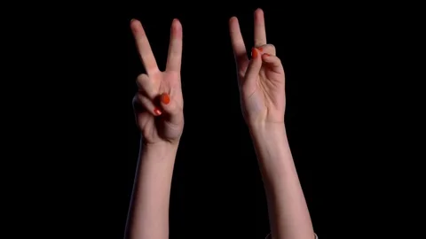 Two hands show a gesture of peace over black background in studio. Stock Footage 118602029