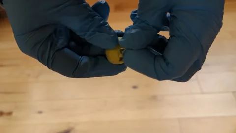 Two hands from the sides of the frame are peeling a very sticky tomatillo Stock Footage 294260618