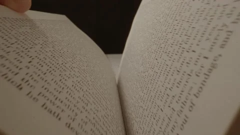 Two hands slowly opening a book as a camera floats over its pages. Alma in Stock Footage 164716743