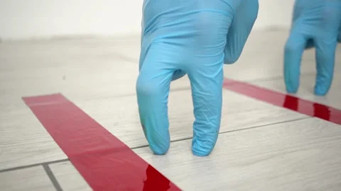 Two hands stand in line behind red tape floor markings for social distancing 動画素材 147156727