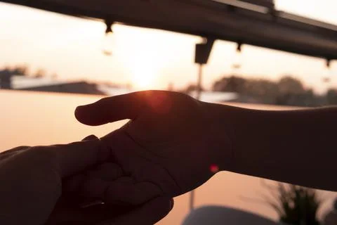 Two hands on sunset Stock Photos