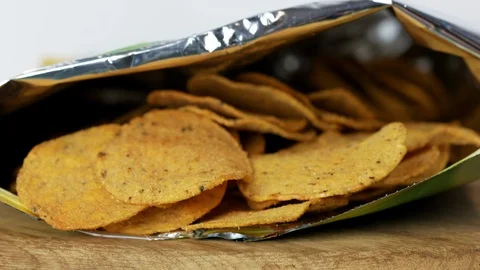 Two hands taking nachos from the package Stock Footage 126936645