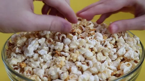 Two hands taking popcorn from bowl Stock Footage 235452983
