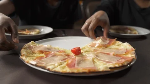 Two hands taking slices of pizza. People eating traditional Italian food in the Stock Footage 122155940