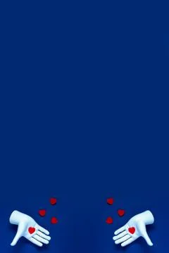 Two hands throw red hearts on a blue background. The concept for Valentine's  写真素材