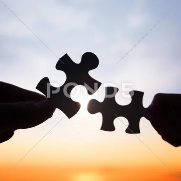 Two hands trying to connect puzzle pieces Stock Photos