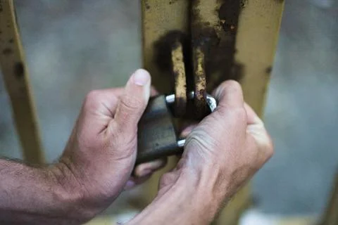 Two hands trying to separate a lock that is locked Stock Photos