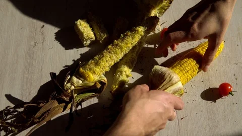 Two hands trying to take one corn cob and begin to take it from each other Stock Footage 91700188