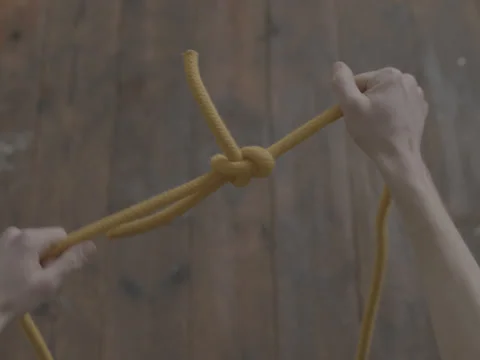 Two Hands Tying a Reef Knot or Square Knot Photographed From Above Top Shot Stock Footage 236406207