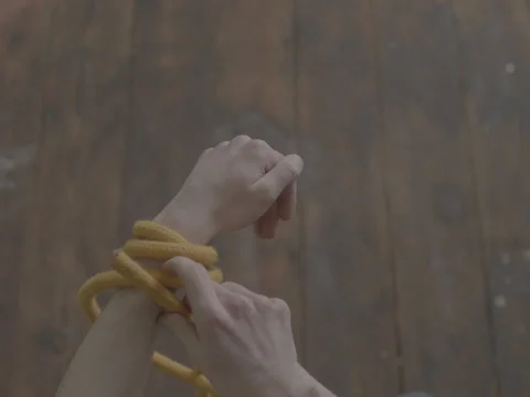 Two Hands Tying a Strangle Knot To Arm Photographed From Above Top Shot Stock Footage 236406522