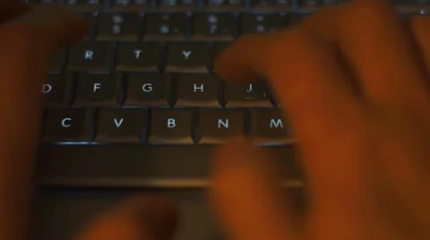 Two hands typing on back lit keyboard in a dark environment Stock Footage 34922858
