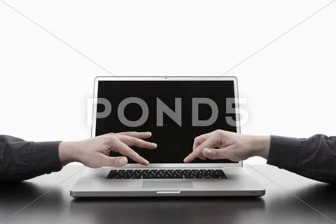 Two hands typing on one laptop keyboard, digital composite Stock Photos