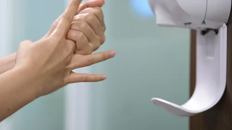 Two Hands under the automatic alcohol dispenser Video stock 128980913