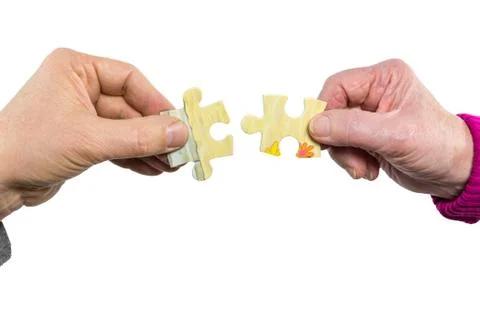 Two hands uniting fitting puzzle pieces Foto stock