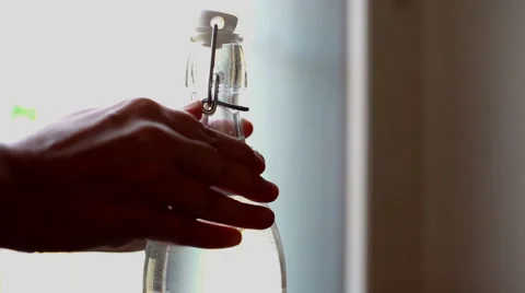 Two hands unlocking a bottle of sparkling water, indoor Stock-Footage 56374857