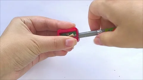 Two hands using pencil sharpener to sharpen pencil Видео 313104790