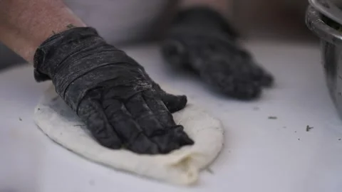 Two hands work to knead dough on a clean surface. Stock Footage 341498652