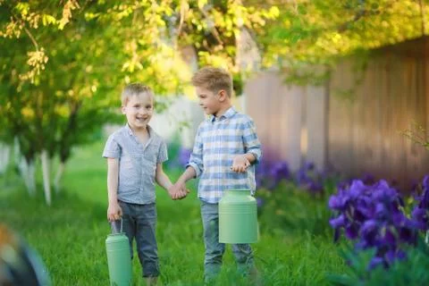 Two handsome brothers having fun while sitting outside in garden Stock Photos