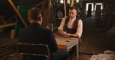 Two handsome elegant dressed men playing cards , Man shaking card before the ill Stock Footage 117682310