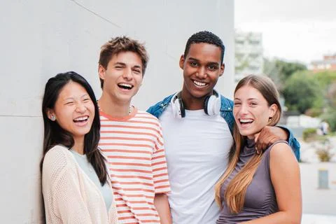 Two handsome men and two teenage women looking at camera standing at university Stock Photos