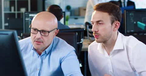 Two handsome men looking for solution to problem over project sitting in the Stock Footage 140284656