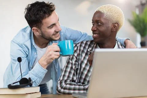 Two handsome men in relations using laptop at home Stock Photos