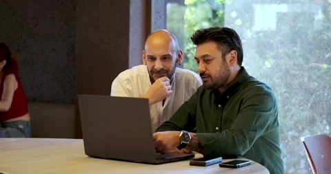 Two handsome middle-aged businessmen, having a pleasant meeting in a cafe Stock Footage 306173828