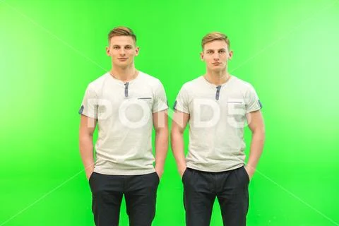 The two handsome twin stand on the green background Stock Photos
