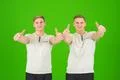 The two handsome twin thumb up on the green background Photo